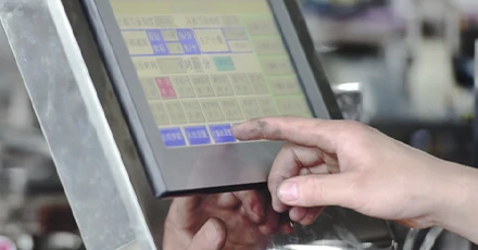 operator performing pouch machine changeover with different bag sizes displayed
